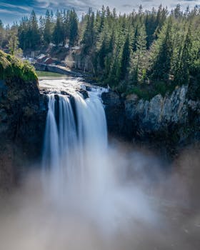 Beautiful view of Snoqualmie Falls in winter with lush evergreen trees and cascade.